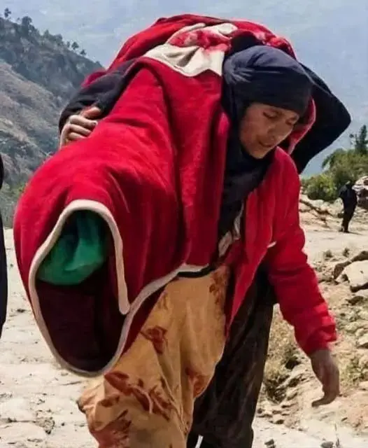 شاهد صورة امرأة تحمل جثمان ابنتها بعد مقتلها في جب...